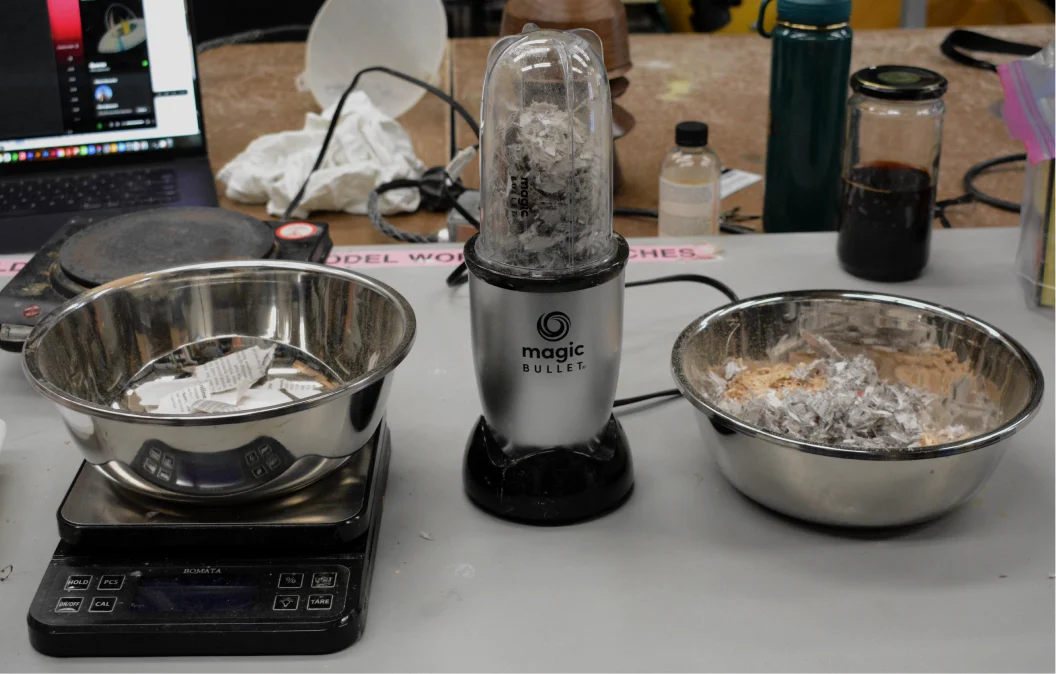 Blender, scale and bowls of shredded paper and sawdust